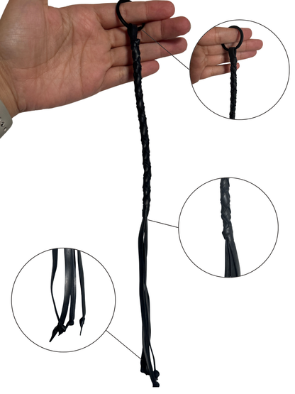 Closeup of black vegan flogger keyring held in hand, highlighting braiding and tails