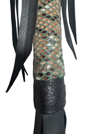 Detail of vegan flogger's reptile-patterned grip and soft faux leather falls