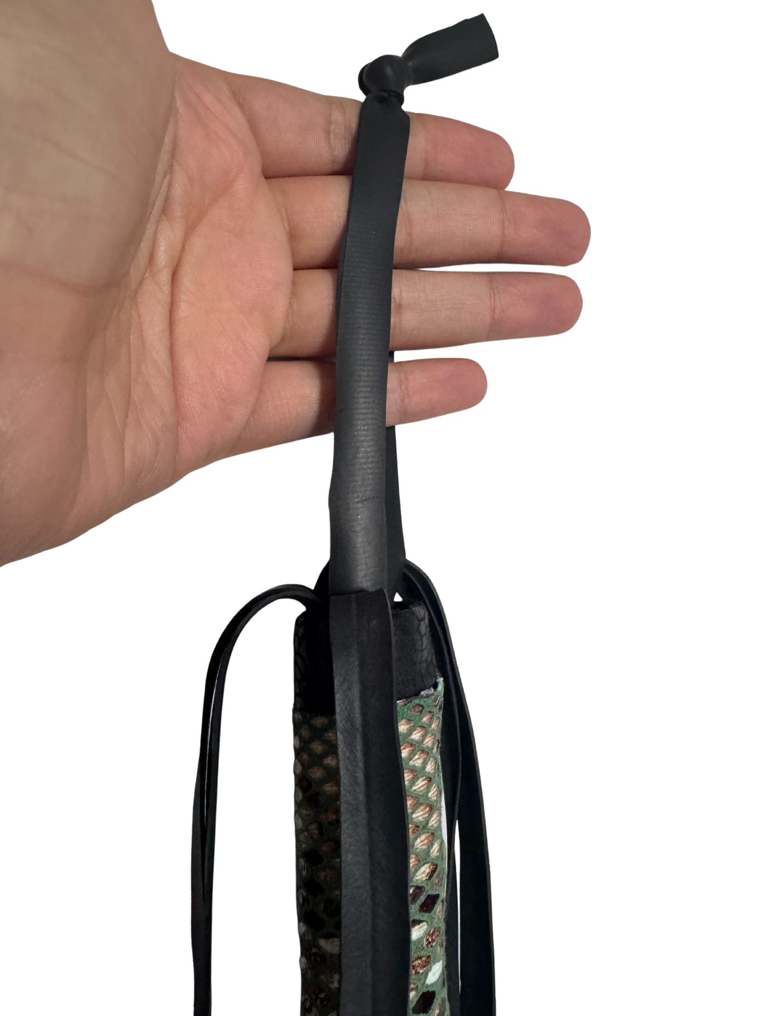 Hand holding flogger showing secure black wrist loop and top detail